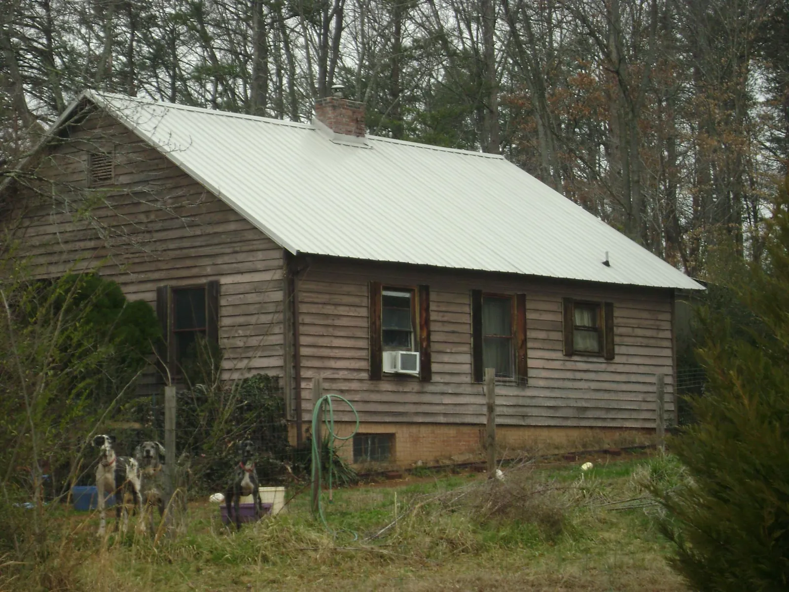 White metal roof on an old wood sided farmhouse, from a Metal Roof Installation job in Ackley